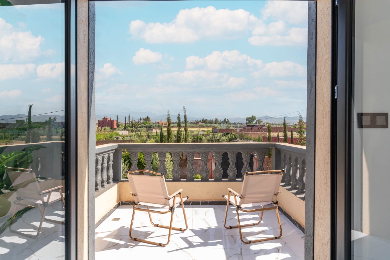Balkon met stoelen en uitzicht op de tuin — Villa Sakinah Marrakech